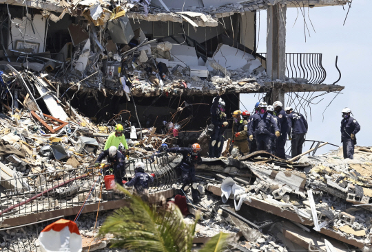27일 미국 플로리다주 마이애미데이드카운티 서프사이드 아파트 붕괴 현장에서 소방대원들이 나흘째 생존자 수색 작업을 벌이고 있다. 이 아파트는 지난 24일 팬케이크처럼 위층에서 아래층으로 겹겹이 쌓이듯 무너지며 잔해 사이에 공간이 없어 구조대원들이 수색에 난항을 겪고 있다. AP연합뉴스