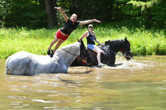 29일 미국 뉴잉글랜드 지역 버넌의 한 강가에서 젊은 여성이 더위를 식히기 위해 말 위에서 강으로 다이빙하고 있다. AP 연합뉴스
