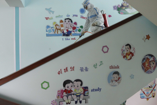 지난달 30일 북한 평양 제4초등학교의 한 직원이 방역복을 입고 학교시설에 대한 소독작업을 벌이고 있다. 김정은 북한 국무위원장은 전날 정치국 확대회의에서 “중대 사건이 발생했다”며 코로나19 방역과 관련해 간부들의 무능과 무책임을 질타하고 문책성 인사까지 단행했다.  AP 연합뉴스