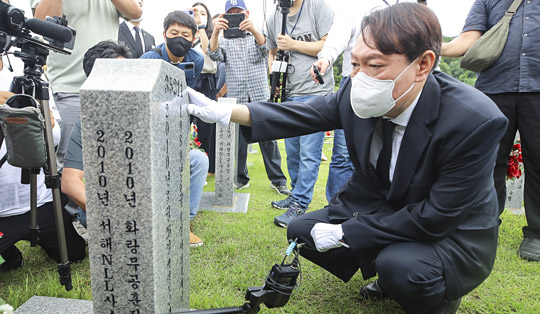 윤석열 전 검찰총장이 6일 오전 국립대전현충원 천안함 46용사 묘역에서 한 병사의 비석을 어루만지고 있다. 곽성호 기자