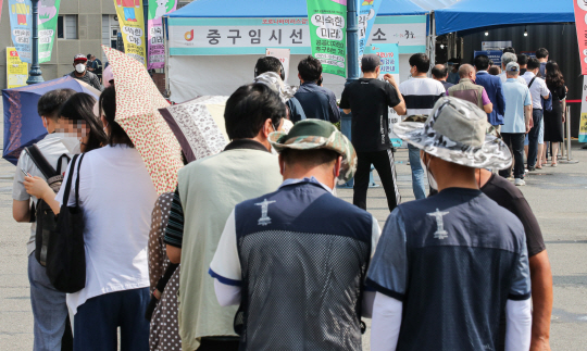 코로나19 확진자가 1주일 연속 700명 이상 나오면서 접촉자도 급증하는 가운데 6일 오전 서울 중구 코로나19 선별검사소에 진단 검사를 받으려는 시민들이 줄지어 서 있다. 연합뉴스