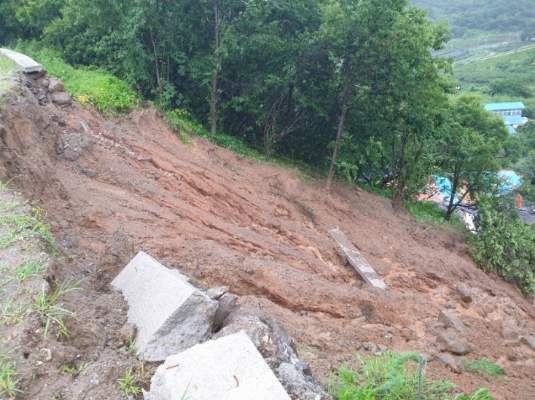 [광양=뉴시스] 6일 오전 전남 광양시 진산면 한 야산에서 산사태가 발생해 인근 민가 4채 중 2채가 매몰되고 2채가 반파됐다. 소방당국은 실종자 1명을 구조·수색하고 있다. (사진=전남소방 제공) 2021.07.06.