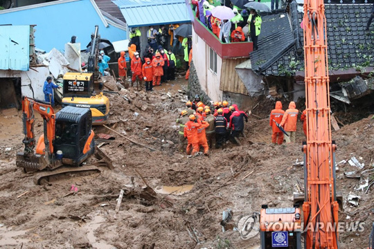 (광양=연합뉴스) 6일 폭우로 산사태가 발생한 전남 광양 진상면의 한 주택에서 구조대원들이 흙더미에 매몰돼 숨진 채 발견된 한 주민을 병원으로 이송하고 있다.