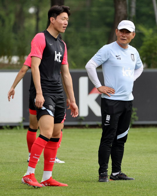도쿄올림픽에 출전하는 남자축구대표팀의 김학범(오른쪽) 감독이 지난 2일 파주 국가대표트레이닝센터에서 진행된 훈련 도중 ‘애제자’ 황의조와 이야기를 나누고 있다.  연합뉴스
