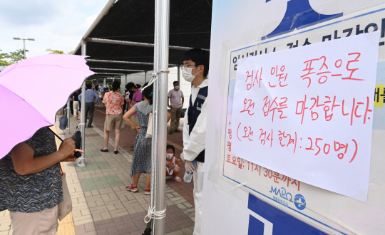 14일 오전 서울 마포구 신수동 서강대역사광장에 마련된 코로나19 임시선별검사소에 검사를 받으려는 시민들이 폭증해 오전 접수 마감을 알리는 안내문이 붙어있다. 신창섭 기자