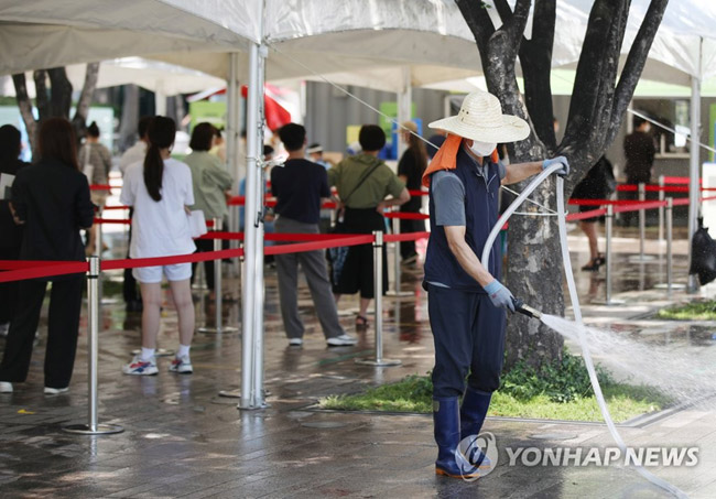 (서울=연합뉴스) 박동주 기자 = 폭염이 이어진 16일 서울광장에 설치된 임시 선별검사소에서 한 작업자가 물을 뿌리며 바닥의 열기를 식히고 있다. 국내 신종 코로나바이러스 감염증(코로나19) ‘4차 대유행’이 지속 중인 가운데 이날 신규 확진자 수가 1천500명대를 기록했다. 2021.7.16
