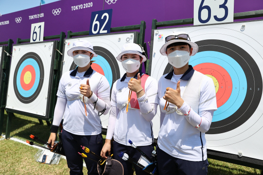 여자양궁대표팀의 안산(오른쪽부터·광주여대), 강채영(현대모비스), 장민희(인천대)가 23일 일본 도쿄의 유메노시마 공원 양궁장에서 열린 도쿄올림픽 개인전 랭킹라운드를 마친 뒤 승리 포즈를 취하고 있다. 안산은 랭킹라운드 신기록을 경신하면서 1위, 장민희가 2위, 강채영이 3위를 차지했다.  연합뉴스