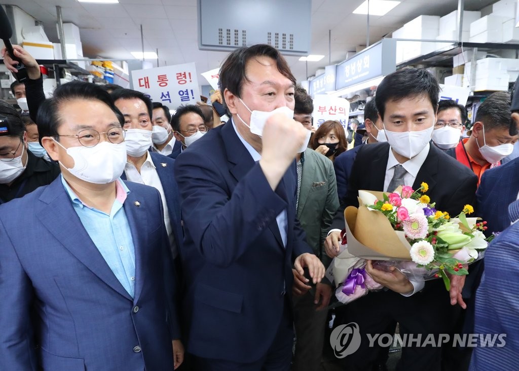 (부산=연합뉴스) 윤석열 전 검찰총장이 27일 오후 부산 중구 자갈치시장을 방문해 상인들의 응원을 듣고 주먹을 치켜올리고 있다. 2021.7.27.[부산사진공동취재단]