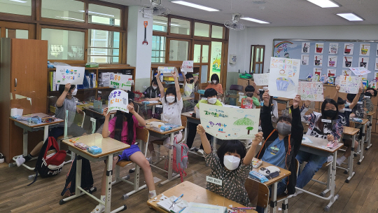 지난달 7일 경기 김포시 고창초등학교 5학년 1반 학생들이 기후·환경 문제 해결을 촉구하는 포스터를 만든 뒤 이를 소개하고 있다.  초록우산어린이재단 제공