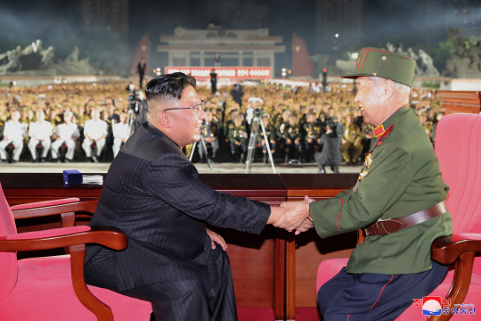 김정은(왼쪽) 북한 국무위원장이 27일 평양 조국해방전쟁승리기념탑에서 열린 제7차 전국노병대회에 참석해 한 노병과 악수하며 이야기를 나누고 있는 장면을 조선중앙통신이 28일 보도했다.  연합뉴스