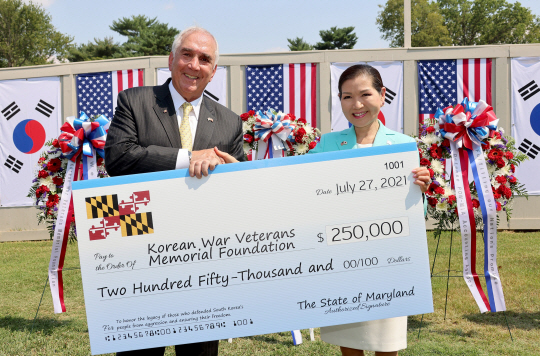 래리 호건 미국 메릴랜드 주지사의 아내인 유미 호건(오른쪽) 여사가 27일 워싱턴DC의 한국전쟁 참전용사 기념공원에서 열린 한국전 정전 기념행사에서 존 틸럴리 한국전참전용사기념재단 이사장에게 성금 25만 달러를 전달하면서 기념사진을 찍고 있다.  메릴랜드 주정부 제공
