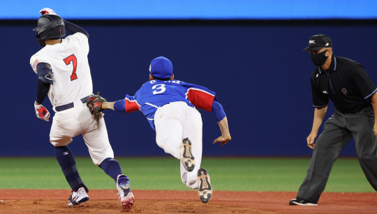 김혜성(키움)이 5일 요코하마 스타디움에서 열린 도쿄올림픽 패자 준결승 2회 말 파브리지오 파브리지 2루심이 지켜보는 가운데 미국의 잭 로페스(7번)를 태그하고 있다.  뉴시스