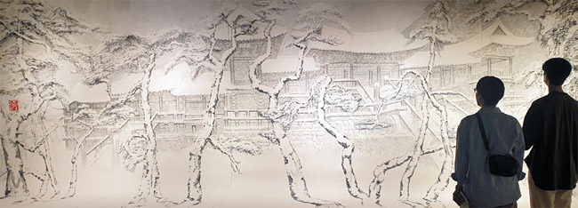 지난 8일 서울 인사아트센터의 박대성 개인전을 찾은 대학생들이 작품 ‘불국설경’(448×199.5㎝, 2021)을 감상하고 있다.
