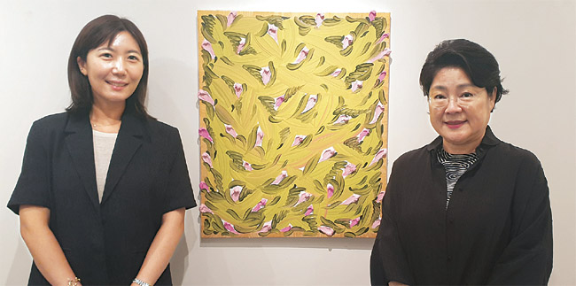 이화익(오른쪽) 대표가 이화익갤러리 20주년 기념전에 참여한 김미영 작가와 함께 김 작가의 작품 ‘화가의 정원’ 앞에서 포즈를 취했다.