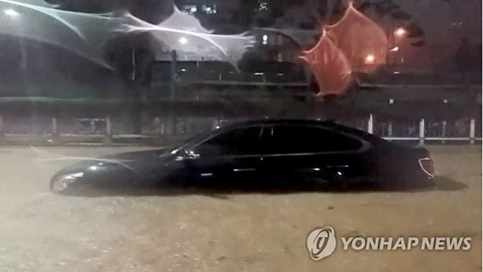 (부산=연합뉴스) 제12호 태풍 오마이스가 지나간 24일 오전 부산 연제구 거제동에서 갑자기 물이 불어나 한 승용차가 침수되어 있다. 2021.8.24. [부산소방본부 제공. 재판매 및 DB 금지]
