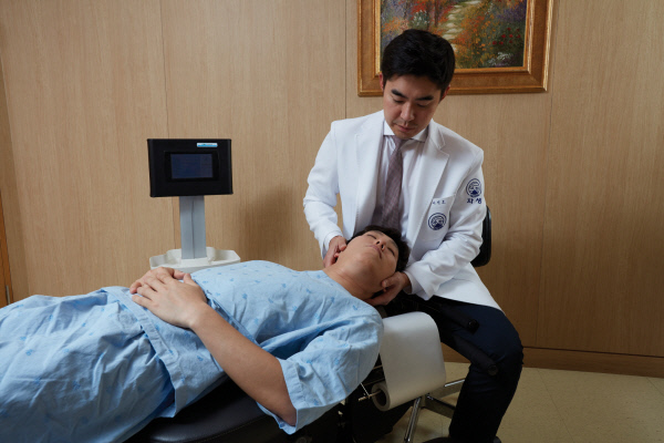 이진호 자생한방병원 병원장이 목디스크 환자에게 추나요법을 실시하고 있다.