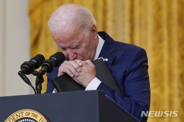 [워싱턴DC=AP/뉴시스] 조 바이든 미국 대통령이 26일(현지시간) 백악관 이스트룸에서 아프간 카불 공항 인근 폭탄 테러에 관한 연설 을 하다가 잠시 발언을 멈추고 고개를 숙이고 있다. 2021.08.27.