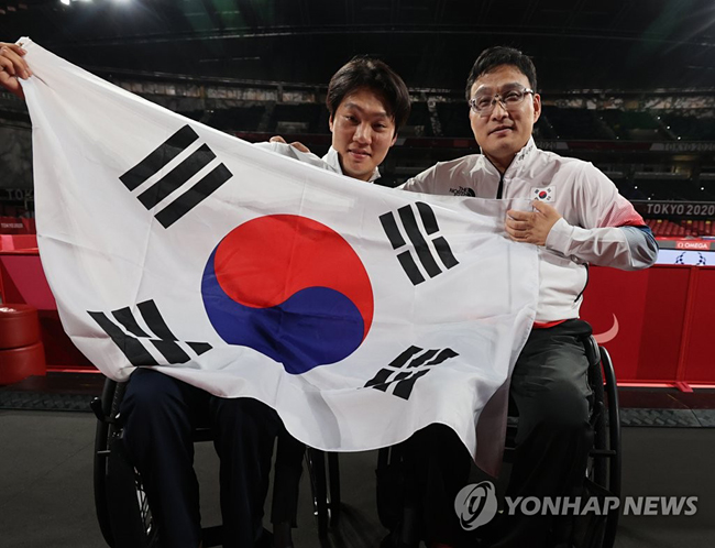 (도쿄=연합뉴스) 서명곤 기자 = 30일 오전 일본 도쿄 메트로폴리탄체육관에서 열린 2020 도쿄 패럴림픽 남자 탁구 개인전(스포츠등급 1) 결승 대한민국의 주영대(오른쪽)가 김현욱을 상대로 세트스코어 3-1로 승리한 뒤 함께 태극기를 들고 포즈를 취하고 있다. 2021.8.30