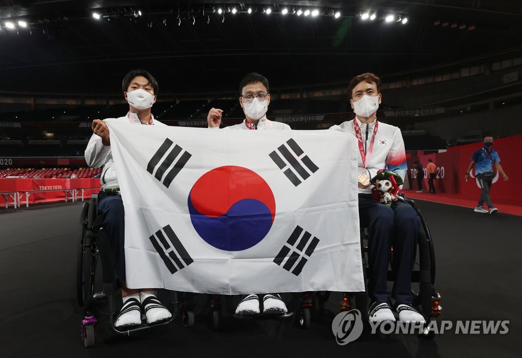 (도쿄=연합뉴스) 30일 오후 일본 도쿄 메트로폴리탄체육관에서 열린 2020 도쿄 패럴림픽 남자 탁구 개인전(스포츠등급 1) 시상식이 끝난 뒤 금메달을 차지한 주영대(가운데), 은메달 김현욱(왼쪽), 동메달 남기원이 함께 태극기를 들고 포즈를 취하고 있다. 2021.8.30
