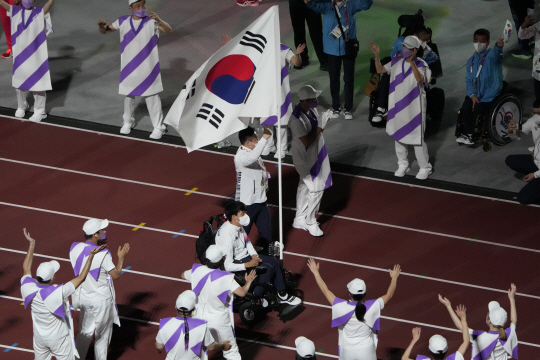 보치아 페어 금메달리스트 정호원이 5일 일본 도쿄 올림픽 스타디움에서 열린 도쿄패럴림픽 폐회식에서 한국 선수단의 기수를 맡아 경기장에 입장하고 있다. AP연합뉴스