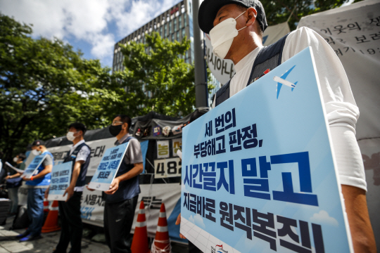 공공운수노조 공항·항공본부 노동자들이 8일 오전 서울 중구 서울지방고용노동청 앞에서 고용유지지원금 연장 등을 촉구하는 피켓을 들고 있다.  뉴시스