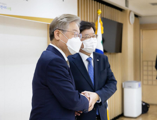 더불어민주당 대선 주자인 이재명(왼쪽) 경기지사가 9일 경기도청에서 염태영 수원시장과 공공기관 이전 부지 활용을 위한 업무협약을 체결하고 기념촬영을 하고 있다. 연합뉴스