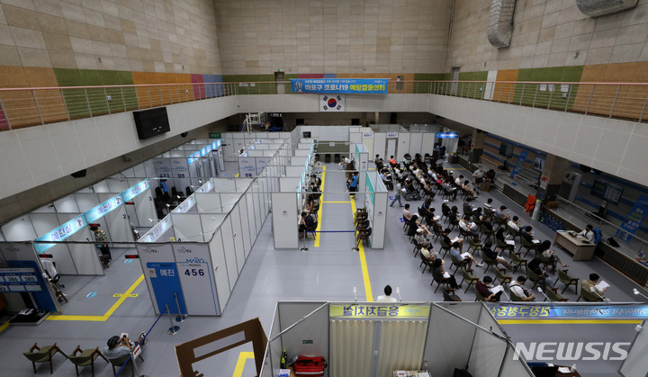 [서울=뉴시스] 지난 9일 오후 서울 마포구 마포아트센터에 마련된 코로나19 예방접종센터에서 시민들이 접종을 받고 모니터링 구역에서 대기하고 있다. 정부는 올해 추석 전 전 국민 1차 접종률 70%, 10월 말까지 접종 완료율 70% 달성을 목표로 하고 있고 현재의 접종추세를 감안해 오는 11월부터 ‘단계적 일상회복’을 검토하고 있다. 한편 이날 코로나19 신규 확진자는 2,049명으로 집계됐다. 2021.09.09.