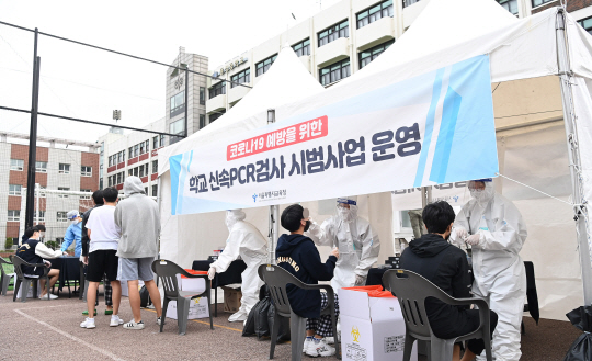 28일 오전 서울 종로구의 동성고 학생들이 서울시 교육청의 ‘신속 자가분자진단 유전자증폭(신속 PCR) 검사’ 시범운영에 따라 등교하면서 코로나19 감염 여부를 판정받고 있다. 사진공동취재단