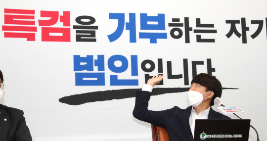 이준석 국민의힘 대표가 30일 오전 국회에서 열린 판교 대장동 게이트 특검법 수용 촉구 긴급 기자회견에서 모두 발언을 한 뒤 ‘특검을 거부하는 자가 범인입니다’라는 백보드를 가리키고 있다. 국회사진기자단