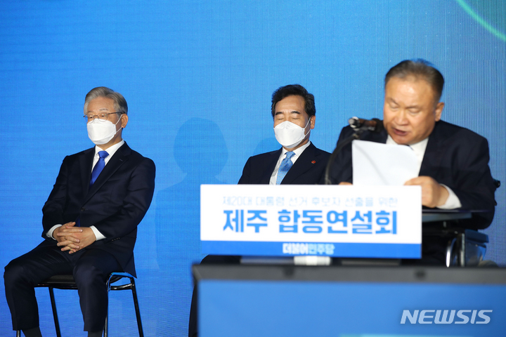 [제주=뉴시스]  1일 오후 제주시 오등동 호텔난타에서 열린 더불어민주당 대선 후보 선출을 위한 제주 합동연설회에서 이재명(왼쪽) 후보와 이낙연 후보가 경선 결과를 기다리고 있다. 이상민(오른쪽) 민주당 대선 경선 선거관리위원장이 결과를 발표하고 있다. 2021.10.01.