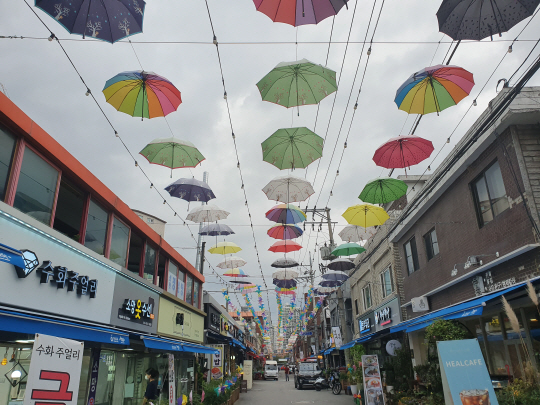 국토교통부의 도시재생뉴딜사업이 추진되고 있는 경기 하남시 신장1동의 한 상점가 공중에 우산과 꼬마전구로 꾸며진 조형물이 설치돼 있다.