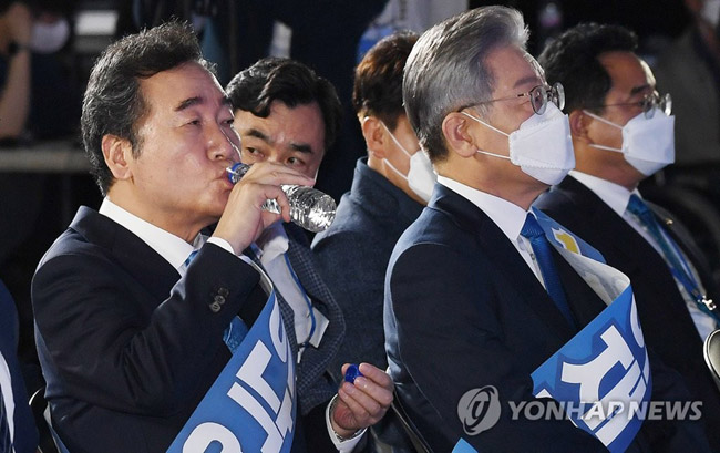 (서울=연합뉴스) 더불어민주당 이낙연 대선 경선 후보(왼쪽)가 10일 오후 서울 송파구 올림픽공원 SK올림픽핸드볼경기장에서 열린 더불어민주당 제20대 대통령선거 후보자 선출을 위한 서울 합동연설회에서 물을 마시고 있다. 오른쪽은 이재명 대선 경선 후보. 2021.10.10 [국회사진기자단]