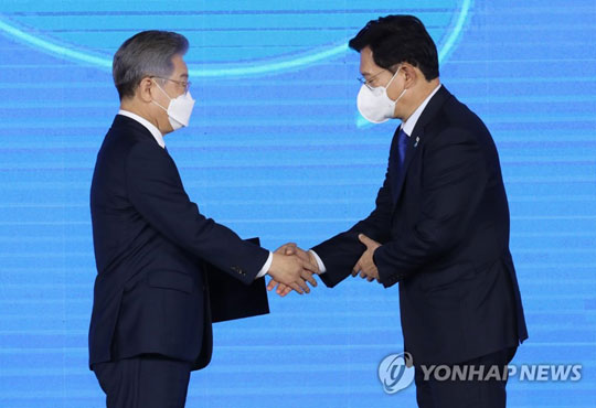 (서울=연합뉴스) 더불어민주당 제20대 대통령 후보에 선출된 이재명 경기도지사가 지난 10일 오후 서울 송파구 올림픽공원 SK올림픽핸드볼경기장에서 열린 서울 합동연설회에서 후보자 추천서를 받은 뒤 송영길 대표와 악수하고 있다. [국회사진기자단]