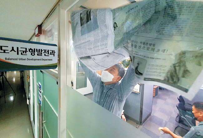 대장동 개발 로비·특혜 의혹 사건을 수사 중인 검찰이 15일 오전 성남시청 압수수색에 들어간 가운데 도시균형발전과 직원들이 신문지로 창을 가리고 있다.