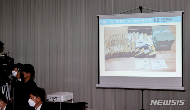 [수원=뉴시스] 경기사진공동취재단 = 김용판 국민의힘 의원이 18일 경기도 수원시 경기도청에서 열린 국회 행정안전위원회의 경기도에 대한 국정감사에서 더불어민주당 대선후보인 이재명 경기도지사의 ‘조폭연루설’을 주장하며 관련 돈다발 사진을 공개하고 있다. 2021.10.18.