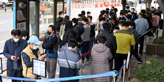 ‘위드 코로나’ 방역체계 전환 사흘을 앞두고 코로나19 확진자가 2124명 발생한 29일 오전 서울 송파구 송파보건소 선별검사소 앞에 이른 아침부터 많은 시민이 길게 줄을 서서 진단검사 차례를 기다리고 있다. 곽성호 기자