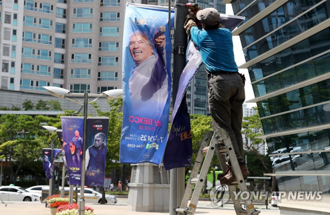 (부산=연합뉴스) 조정호 기자 = 지난 7월 22일 부산 해운대구 벡스코에서 가수 나훈아 공연 홍보 현수막이 철거되고 있다. 당초 23∼25일 예정된 ‘나훈아 어게인 테스형’ 부산 콘서트는 비수도권 공연 금지에 따라 다음 달로 연기됐다. 2021.7.22 [연합뉴스 자료사진]