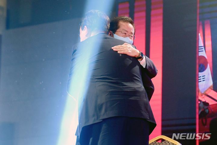 [서울=뉴시스] 최진석 기자 = 국민의힘 제20대 대통령 선거 후보에 선출된 윤석열 전 검찰총장이 5일 오후 서울 용산구 백범김구기념관에서 열린 제2차 전당대회에서 개표결과 발표 후 홍준표 후보와 포옹을 나누고 있다. (공동취재사진) 2021.11.05.