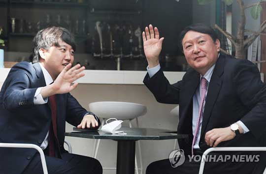 (서울=연합뉴스) 국민의힘 이준석 대표(왼쪽)와 윤석열 대선 후보가 6일 오후 서울 마포구 한 음식점에서 오찬 회동 중 창밖에 모인 시민들을 향해 손을 흔들고 있다. 2021.11.6