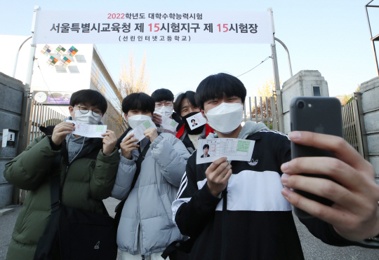 2022학년도 대학수학능력시험을 하루 앞둔 17일 오전 수능 예비소집 장소인 서울 용산구 선린인터넷고를 찾은 학생들이 수험표를 들고 사진을 찍으며 환하게 웃고 있다.  연합뉴스