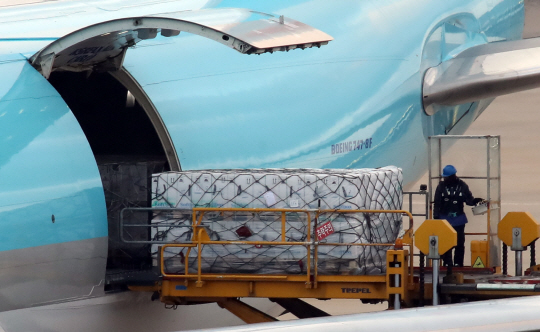 방역요원들이 지난 22일 오후 항공편을 통해 인천국제공항 화물터미널에 도착한 화이자 백신 256만 회분을 하역하고 있다.  연합뉴스