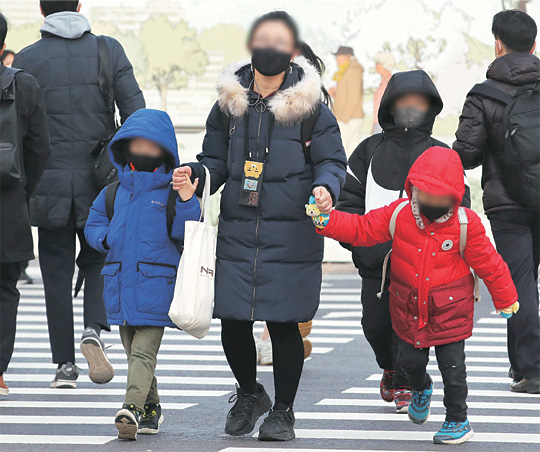서울 아침기온이 영하 1.1도를 기록한 24일 오전 두꺼운 방한복 차림의 학부모와 자녀들이 서로 손을 꼭 잡고 등교를 위해 서울 광화문 사거리 횡단보도를 건너고 있다.  뉴시스