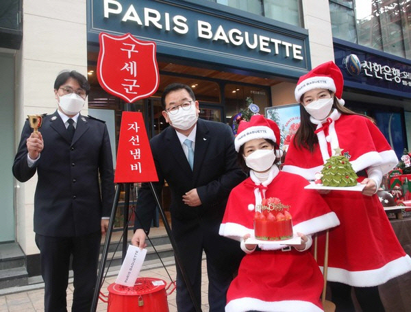 이명욱(가운데) 파리크라상 대표이사가 23일 오전 서울 중구 파리바게뜨 명동본점에서 구세군 1호 성금을 자선냄비에 넣고 있다.