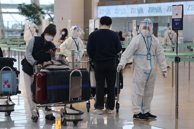 신종 변이인 오미크론 의심환자가 국내에서 발생한 가운데 인천국제공항 방역요원이 지난달 30일 국제선 탑승 수속장에서 발열 체크와 백신 접종 증명서를 확인하고 있다.  연합뉴스