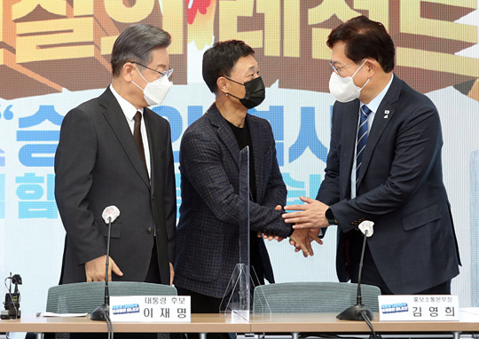 송영길(오른쪽) 더불어민주당 대표가 2일 오전 서울 여의도 당사에서 이재명(왼쪽) 대선 후보가 바라보는 가운데 홍보소통본부장으로 영입한 김영희 전 MBC 부사장과 악수하고 있다.