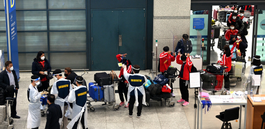 코로나19 변이 바이러스 오미크론의 국내 유입을 막기 위해 ‘모든 입국자 10일 의무 격리’ 조치가 시행된 3일 오전 인천국제공항 검역 관계자들이 줄지어 대기 중인 입국자들에게 달라진 검역 및 입국 절차를 안내하고 있다.