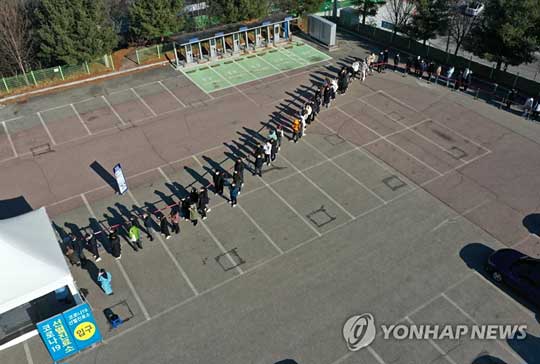 (춘천=연합뉴스) 5일 오전 강원 춘천시 호반체육관 인근에 마련된 신종 코로나바이러스 감염증(코로나19) 선별진료소에서 시민들이 줄지어 검사를 기다리고 있다. 강원도는 최근 나흘 동안 1일 평균 확진자 수가 100명 이상 발생했다. 2021.12.5