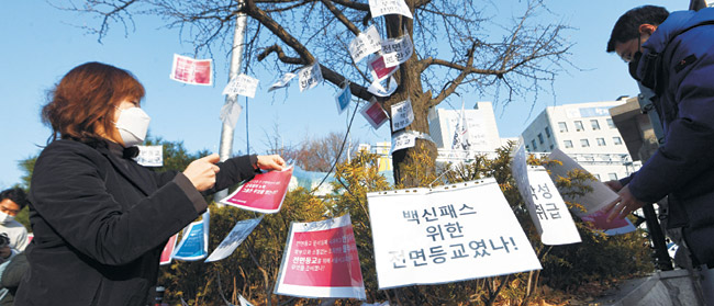 내년 2월 청소년 ‘방역 패스’ 적용 방안에 학부모들이 거세게 반발하는 가운데, 7일 오전 서울시학부모연합회 회원들이 서울시교육청 앞에서 청소년 방역패스 적용 반대 문구를 시교육청 앞 나무에 붙이고 있다.