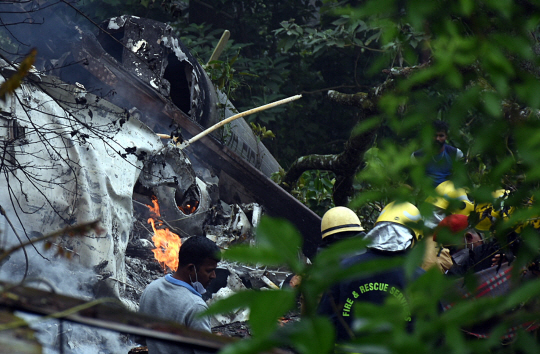 인도 구급대원들이 8일 타밀나두주 쿠누르에서 추락한 공군 헬기 잔해에서 시신을 수습하고 있다. 이 사고로 헬기에 탑승했던 비핀 라와트 인도 국방 합참의장이 사망했다. EPA 연합뉴스