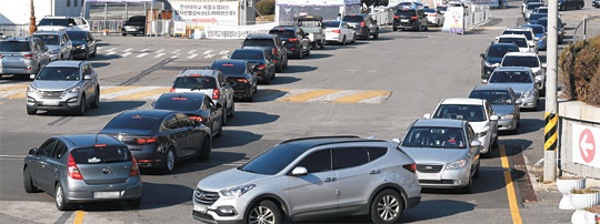 8일 인천 미추홀구에 마련된 드라이브스루(탑승형) 임시선별검사소에 코로나19 검사를 받기 위해 몰려든 주민들이 차량에 탑승해 길게 줄지어 서 있다.